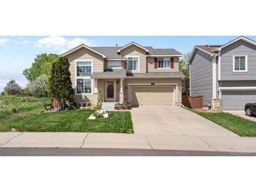 Charming two-story home featuring a well-manicured front lawn and attached two-car garage at 408 Sylvestor Trl, Highlands Ranch, CO 80129