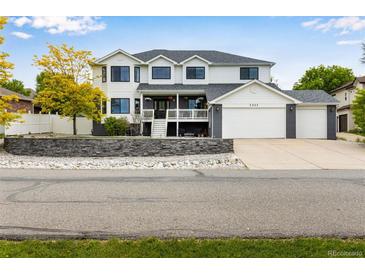 Charming two-story home features a three-car garage, front porch, and beautiful landscaping at 1311 Fletcher Dr, Erie, CO 80516