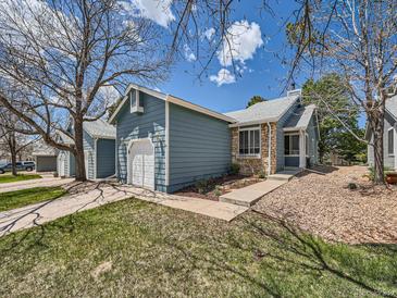 Charming exterior of a blue home featuring stone accents and well-maintained landscaping at 31 Shetland Ct, Highlands Ranch, CO 80130