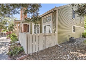Charming home with an attractive exterior, complemented by a white picket fence and lovely landscaping at 14076 E Radcliff Cir, Aurora, CO 80015