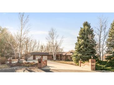 Charming brick home with manicured landscaping and a spacious driveway leading to a three-car garage at 103 Red Wing Ct, Mead, CO 80542