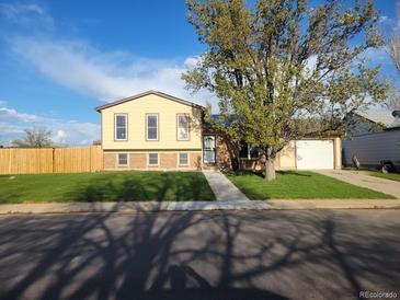 Charming two-story home with a well-maintained lawn and attached two car garage at 1104 S Biscay St, Aurora, CO 80017