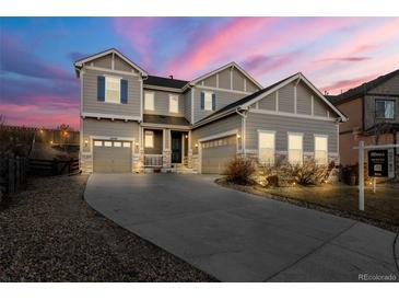 Charming two-story home with gray siding, stone accents, and well-manicured front yard at 21028 E Saratoga Ave, Aurora, CO 80015