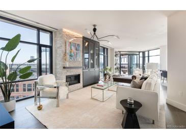 Bright living room with modern fireplace, sleek lighting fixture, floor to ceiling windows and city views at 1901 Wazee St # 1020, Denver, CO 80202