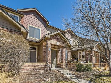 Charming townhome featuring a brick facade, covered entry, and well-maintained landscaping at 6426 Silver Mesa Dr # C, Highlands Ranch, CO 80130