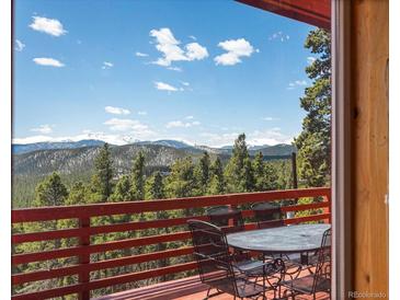 Open deck with views of mountains and trees offers a relaxing outdoor dining space at 451 Harris Dr, Idaho Springs, CO 80452