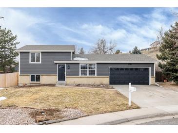 Charming two-story home with gray siding, black door, two-car garage, and well-manicured lawn at 11186 W Wisconsin Ave, Denver, CO 80232