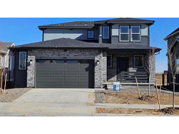 Beautiful two-story home featuring a stone facade, two-car garage, and well-manicured lawn at 490 Grey Rock St, Brighton, CO 80601