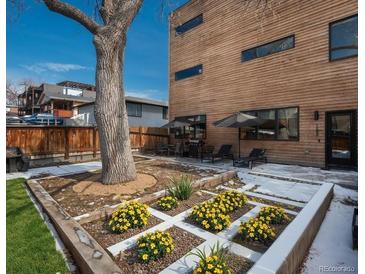 Landscaped backyard featuring a cozy patio area with an outdoor kitchen and lovely garden beds at 1260 Newton St # 1, Denver, CO 80204