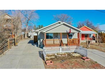 Gray house with wooden porch, white picket fence, and small garden at 2881 W 65Th Ave, Denver, CO 80221