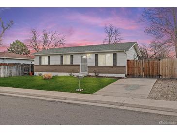Charming single story home featuring well manicured lawn and long driveway at 5562 Anaheim Way, Denver, CO 80239
