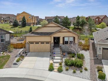 Charming home featuring a well-manicured front yard and attached two-car garage with stone accents at 4077 Forever Cir, Castle Rock, CO 80109