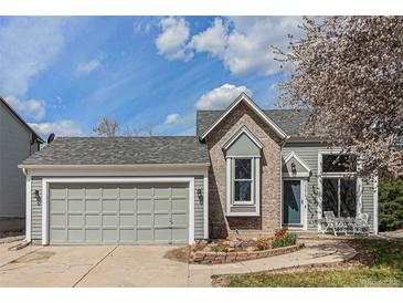 Charming home with a two-car garage, blue door, and a beautiful flower garden at 10275 Quail St, Westminster, CO 80021