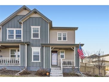 Two-story townhome with gray and beige siding, front porch, and American flag at 2932 Low Meadow Blvd, Castle Rock, CO 80109