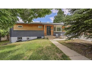 Charming home with a modern exterior, painted brick and light wood, inviting front yard, and a cozy sitting area at 12020 W Alabama Pl, Lakewood, CO 80228