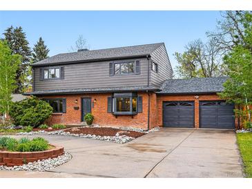 Beautifully landscaped home with a brick and siding exterior, a spacious driveway, and a two-car garage at 2448 S Leyden St, Denver, CO 80222