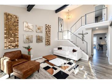 Bright living room with modern decor, high ceilings, sleek metal staircase, and stylish furniture at 6980 Fargo Trl, Littleton, CO 80125