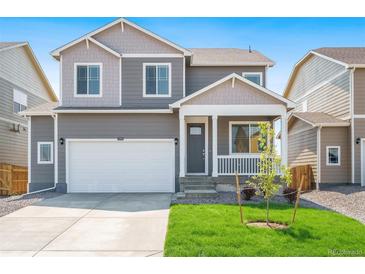 Two-story house with gray siding, white garage door, and landscaped lawn at 15963 Syracuse St, Thornton, CO 80602