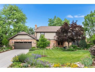 Charming two-story home with brick and siding, mature trees, a well-manicured lawn, and a two-car garage at 5185 W Fair Pl, Littleton, CO 80123