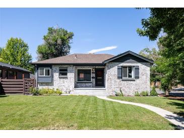 Charming exterior of a ranch-style home with a manicured lawn, whitewashed brick, and updated black trim at 2995 N Cherry St, Denver, CO 80207