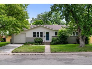 Charming single-story home featuring a well-manicured lawn, mature trees, and inviting curb appeal at 6402 Iris Ct, Arvada, CO 80004