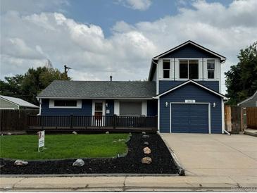 Two-story home with a blue exterior, landscaping, and a two-car garage at 2670 S Hooker St, Denver, CO 80219