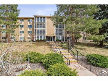 Three-story condo building with glass-enclosed patios and a landscaped lawn at 3022 S Wheeling Way # 407, Aurora, CO 80014