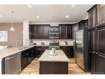 Well-equipped kitchen with stainless steel appliances, granite counters, and ample cabinet space at 8183 S Yosemite Ct, Centennial, CO 80112