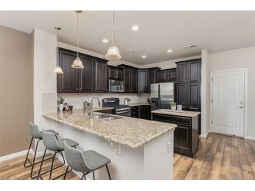Modern kitchen featuring granite countertops, stainless steel appliances, and dark wood cabinetry at 8183 S Yosemite Ct, Centennial, CO 80112
