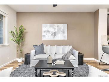 Cozy living room featuring a white sofa, modern art, and stylish decor at 8183 S Yosemite Ct, Centennial, CO 80112