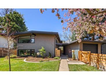 Modern home with wood siding, fresh landscaping, and a walkway leading to the front door at 1485 S Jasmine Way, Denver, CO 80224