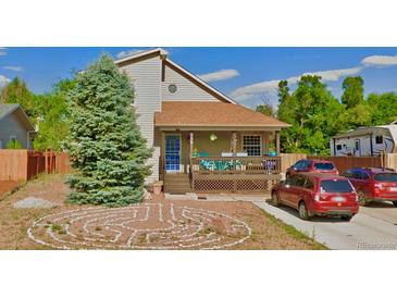 Charming home with a welcoming front porch, well-manicured lawn and a rock garden in the front yard at 596 Trumbull Ln, Monument, CO 80132
