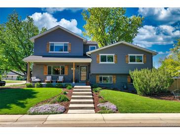 Charming two-story home with gray siding, brick accents, wood shutters, and a beautifully landscaped front yard at 1750 E Noble Pl, Centennial, CO 80121
