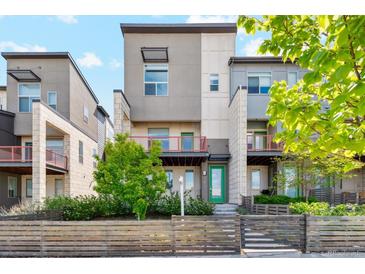 Modern townhome with a neutral exterior, colorful accents, and landscaping at 5682 N Galena St, Denver, CO 80238