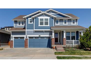Charming two-story home with a three-car garage and a beautifully landscaped front yard at 18315 W 83Rd Dr, Arvada, CO 80007