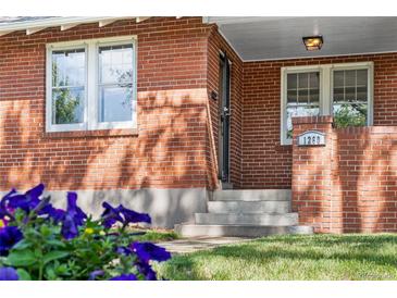 Charming brick home entrance featuring a classic design, complemented by lush greenery and an inviting ambiance at 1260 S Emerson St, Denver, CO 80210