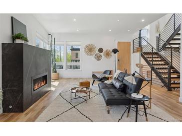 Bright living room features a modern fireplace, hardwood floors, and contemporary furnishings at 1801 W 33Rd Ave, Denver, CO 80211