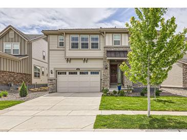 Beautiful two-story home with a well-manicured lawn and a two car garage on a sunny day at 3162 Grizzly Peak Dr, Broomfield, CO 80023