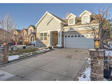 Two-story house with gray siding, brick accents, and a two-car garage at 23975 E Arizona Pl, Aurora, CO 80018