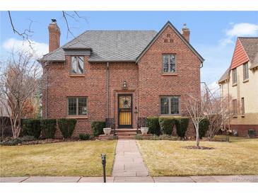 Charming brick two-story home with manicured lawn, slate roof and welcoming front entry at 945 Niagara St, Denver, CO 80220