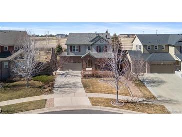 View of a well-maintained two-story home with brick and siding, plus a two car garage at 129 N Irvington St, Aurora, CO 80018