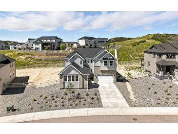 Beautiful two-story home with a modern design, well-manicured front yard, and a two car garage at 1672 Fox Trotter Pt, Castle Rock, CO 80104