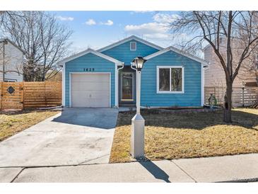 Charming blue single-story home featuring a front lawn, attached garage, and inviting front entrance at 1625 19Th Ave, Longmont, CO 80501