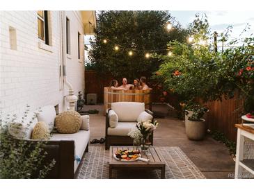 Inviting backyard with a wooden hot tub, outdoor seating, and string lights for relaxing evenings at 4212 Lowell Blvd, Denver, CO 80211