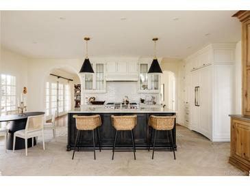 Bright kitchen featuring a large island with bar stool seating and modern pendant lighting at 5700 S Steele St, Greenwood Village, CO 80121