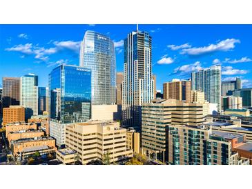 Stunning cityscape view with modern glass buildings against a bright blue sky with scattered clouds at 1133 14Th St # 4150, Denver, CO 80202