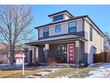 Inviting two-story home with stylish brick accents, a red front door, and a cozy front porch at 2122 S Ogden St, Denver, CO 80210