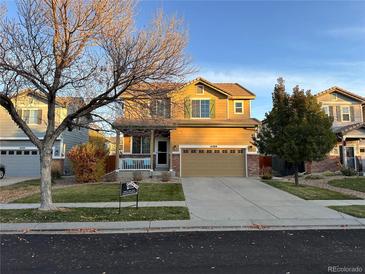 Two-story house with attached garage and front porch at 14389 E 101St Pl, Commerce City, CO 80022