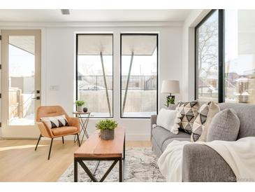 Bright living room features a comfy sofa, large windows, and stylish coffee table at 3433 Lawrence St # 1, Denver, CO 80205