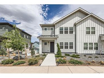 Charming two-story home featuring white siding, landscaped front yard, and inviting walkway at 8822 Fraser River Loop, Littleton, CO 80125